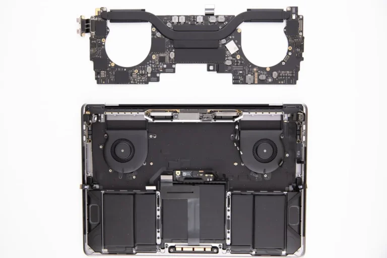 Disassembled view of a laptop showing the internal chassis with cooling fans and battery, and the removed motherboard above.