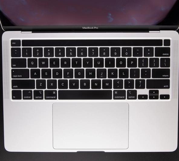 Top-down view of an Apple MacBook Pro keyboard and trackpad, featuring the US QWERTY layout and sleek aluminum chassis design.